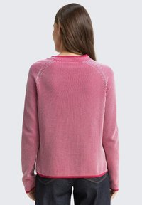 Czerwono-biała sweter w paski z długimi rękawami, żeberkowaną strukturą, okrągłym dekoltem i kontrastowym wykończeniem. Miękka tkanina, luźny krój.