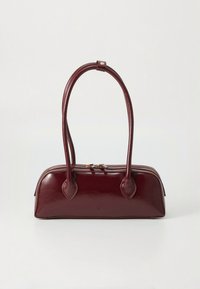 Sac à main en cuir bordeaux avec deux anses allongées, une forme arrondie, une texture lisse et une fermeture éclair en haut.