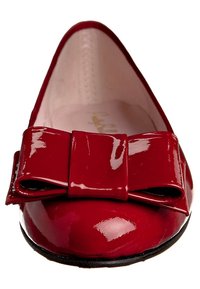 Bailarina de charol rojo con un gran lazo decorativo en la puntera. El interior es de color rosa claro y el zapato tiene una forma redondeada.