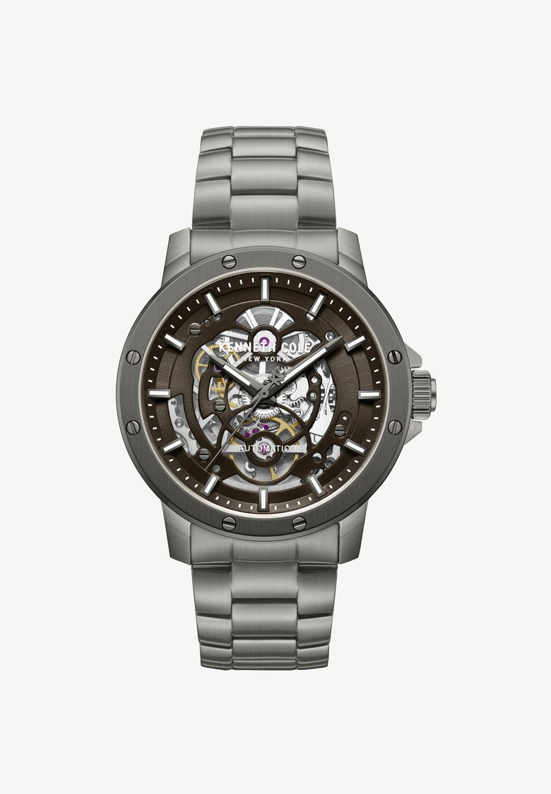 Pánske automatické hodinky z nehrdzavejúcej ocele so skeletónovým ciferníkom zobrazujúcim vnútorné ozubené kolieska, svietiace hodinové značky a kovovým náramkom s pántmi.