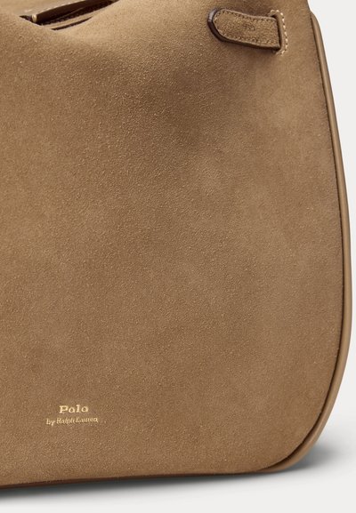 Sac à main en daim marron avec une texture lisse, une forme arrondie et un logo en feuille d'or qui indique "Polo by Ralph Lauren" sur le devant.