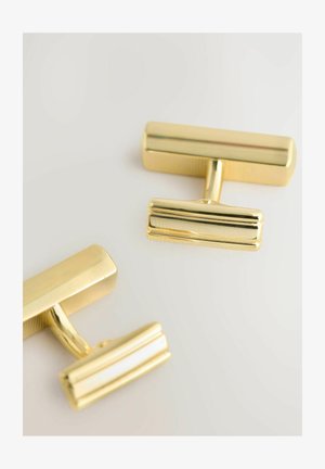 Goldene Manschettenknöpfe mit rechteckigem Design, glatter, polierter Oberfläche und strukturiertem Griffdetail am verbindenden Steg.