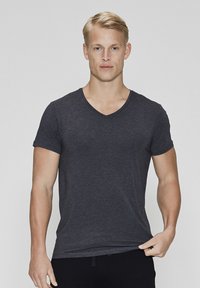 Charcoal gray short-sleeve V-neck t-shirt made of soft fabric, featuring a fitted design and smooth texture, worn with dark pants.