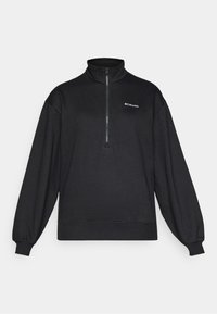 Pullover in pile nero, con mezzo zip, maniche lunghe, vestibilità ampia, polsini e orlo a coste, con logo bianco in alto a sinistra.