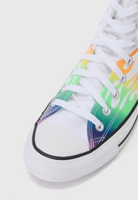 Höga sneakers med en vit canvastyg och ett livligt ombre-mönster i grönt, gult, orange och lila. Gummitå och sula.