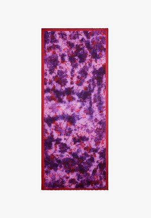 Tessuto tie-dye viola e rosso con motivi a spirale, bordato da un trimm rosso uniforme. Texture liscia con sfumature di colore variabili.