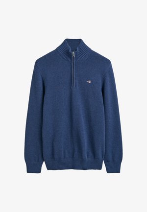 Pull en bleu marine avec un col côtelé haut et une fermeture éclair quart. Fabriqué dans un matériau doux avec des poignets et un ourlet côtelés, arborant un petit logo.