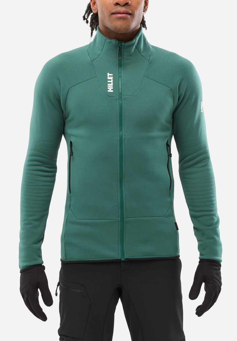 Grüne Fleecejacke mit vollem Reißverschluss, hohem Kragen und zwei Reißverschlusstaschen. Aus elastischem Material und mit tailliertem Schnitt für mehr Beweglichkeit.