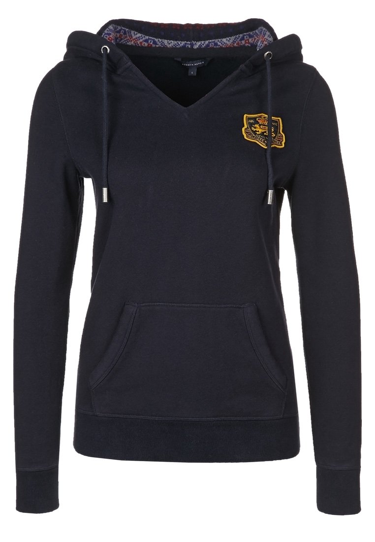 Marinblå hoodie med v-ringning, dragsko, framficka och ett inre mönstrat foder. Har en broderad logotyp på bröstet.