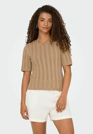  Haut en tricot beige à manches courtes avec une texture côtelée et un ourlet festonné. Associé à un short blanc, il présente une coupe décontractée et un col rond.