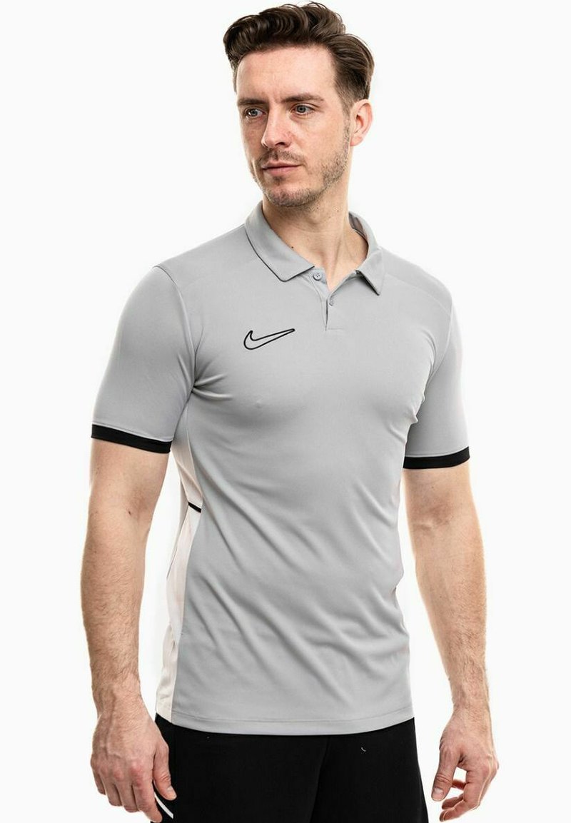 Graues Polo-Shirt aus glattem Stoff mit schwarzem Nike-Logo und kontrastierenden schwarzen Akzenten an den kurzen Ärmeln. Klassisches Kragen-Design.