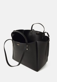 Černá kožená taška přes rameno se zlatými akcenty, otevřený design, viditelná vnitřní struktura, dvě krátké ucha a jeden dlouhý popruh.