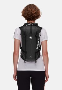 Plecak w czarno-szare kratki z regulowanymi paskami, górnym zamknięciem na sznurek i bocznymi klamrami. Posiada logo i strukturalny materiał.