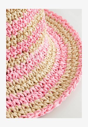 Kootud õlgkübar, millel on vahelduvad roosa ja looduslike beežide sektsioonid, lai äär ja tekstureeritud pind ümmarguse kujuga.