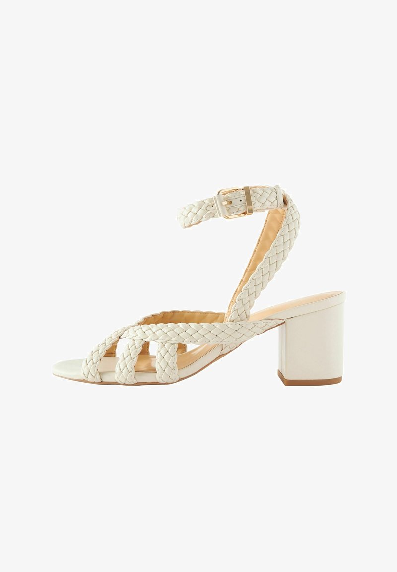 Sandale blanche à bride cheville tressée avec talon bloc et bout ouvert, équipée d'une fermeture à boucle et d'un design en cuir tissé.