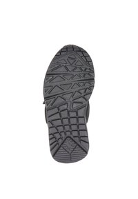 Zwarte rubberen schoenzool met een textuur en multidirectioneel profiel, met hoekige en driehoekige vormen voor grip en tractie.