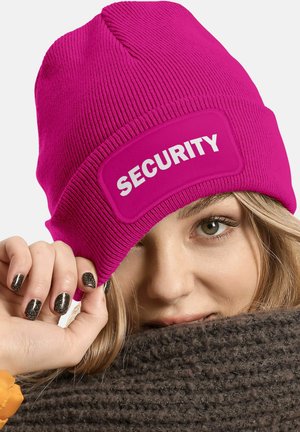 Pink knit beanie featuring a prominent "SECURITY" patch in white. Close-fitting design, ribbed texture, worn at an angle.