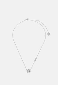 Collier en argent avec un pendentif circulaire orné d'une pierre claire entourée de petites pierres, incluant un détail d’accent triangulaire.