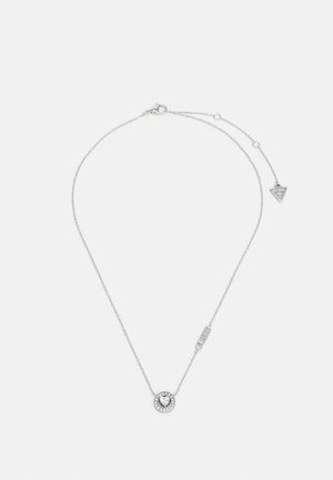 Hõbedast kettkaelakee, millel on ümmargune ripats, mille keskel on selge kivi, ümbritsetuna väiksematest kividest ning millel on kolmnurkne detail.