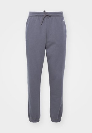 Pantaloni tuta grigi in felpa con vita elasticizzata e coulisse. Orli a costine e tasche laterali. Tessuto morbido adatto per abbigliamento casual.