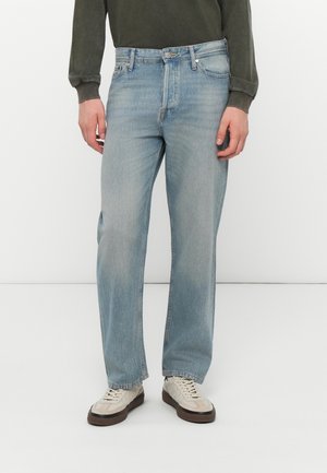 Lichtblauwe denim jeans met een rechte pasvorm, voorzien van subtiele vervaging en een klassiek vijf-pocket ontwerp. Gemaakt in combinatie met beige schoenen en een donkere top.