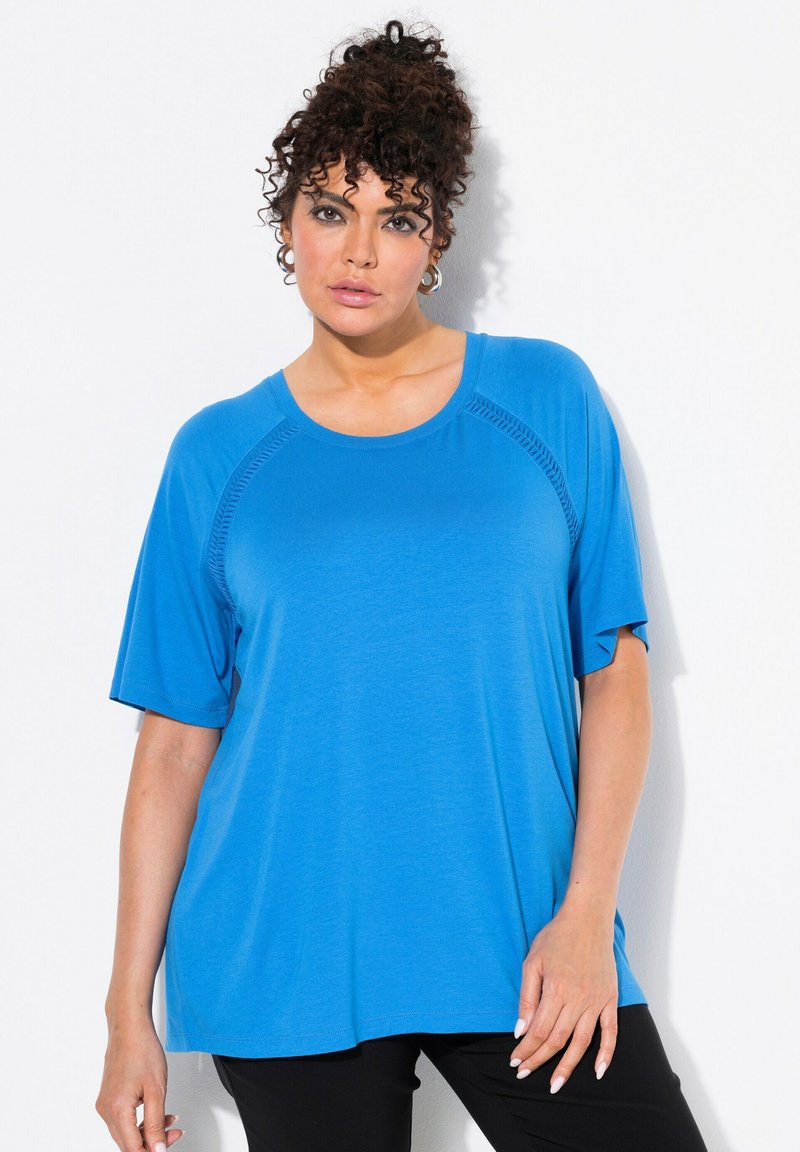 Top blu corto a maniche corte con scollatura rotonda e vestibilità rilassata. Tessuto morbido e leggero con dettagli di cucitura laterale discreti.