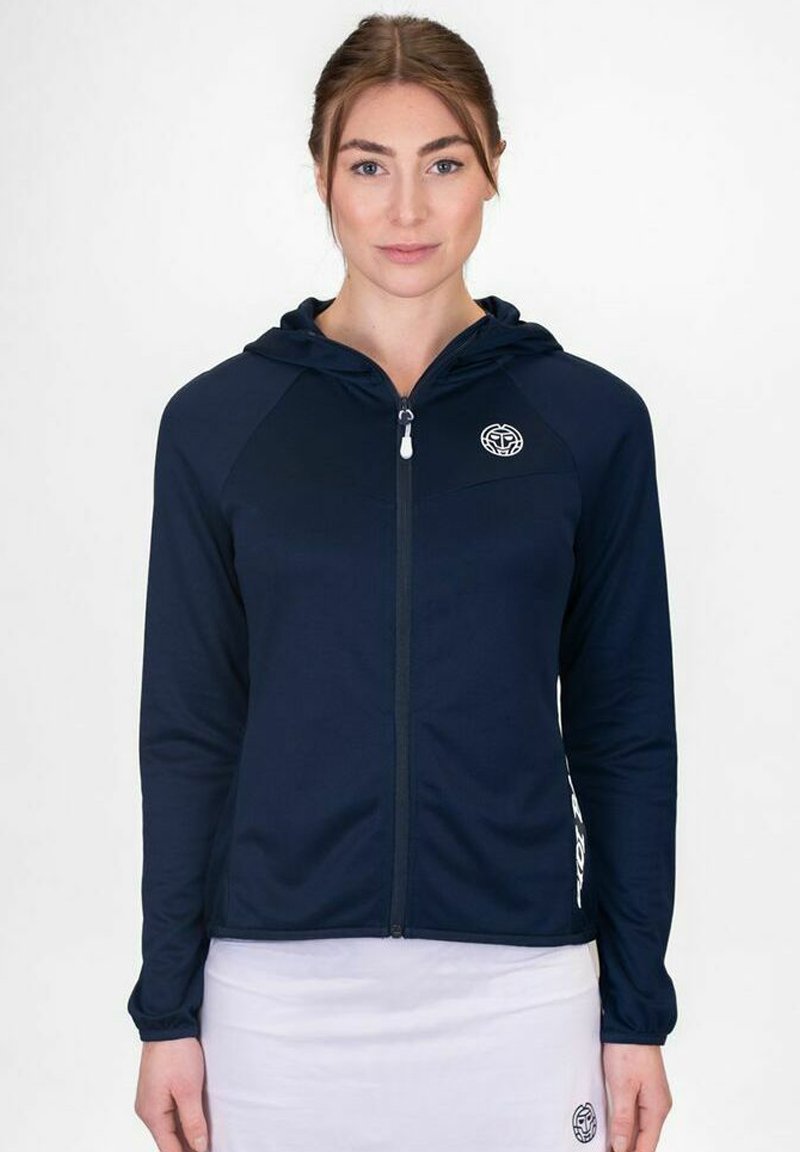 Sudadera con cremallera en color navy, con capucha redondeada, un logo en el lado izquierdo del pecho y mangas largas. Tejido suave con una textura aterciopelada y un diseño ajustado.