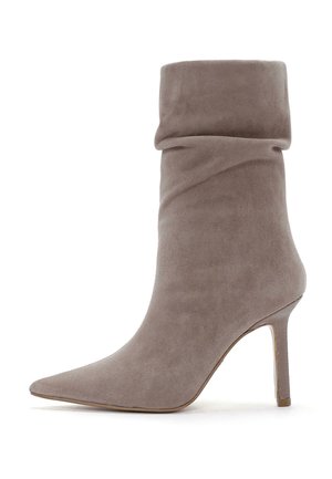 Bottine en daim gris avec un revers décontracté, un bout pointu et un fin talon haut, présentant une texture lisse et un design minimaliste.