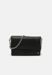 Borsa a spalla in pelle nera con tracolla in metallo argentato e design piegato. Presenta un logo discreto sulla parte frontale e una texture liscia.
