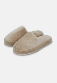 Beige tygtofflor med en mjuk, strukturerad ovansida, öppen baksida och vit sula. Har präglad "LUN"-logotyp på framsidan.