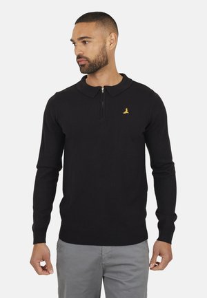 Maglione polo nero a maniche lunghe con colletto zip, con un piccolo logo dorato sul lato sinistro del petto. Texture a maglia liscia.
