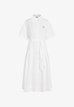 Balta midi kleita ar īsām piedurknēm, apkakli, pogu priekšpusi, sapulcinātu vidukli, auduma jostu un nelielu uzrakstu kreisajā krūtīs.