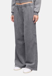 Grijze sweatpants met wijde pijpen, een elastische tailleband, decoratieve stiksels en een subtiele logodetail. Glad textuur. Geschikt voor casual gebruik.