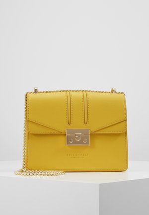 Sac bandoulière en cuir jaune avec une chaîne dorée et un fermoir rectangulaire doré sur une surface blanche.