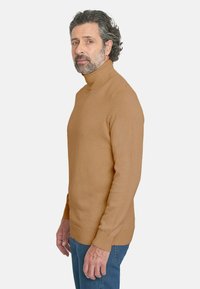 Jersey de cuello alto hecho de una tela suave en un cálido color beige. Presenta mangas ajustadas y ribetes acanalados en el cuello y el dobladillo.