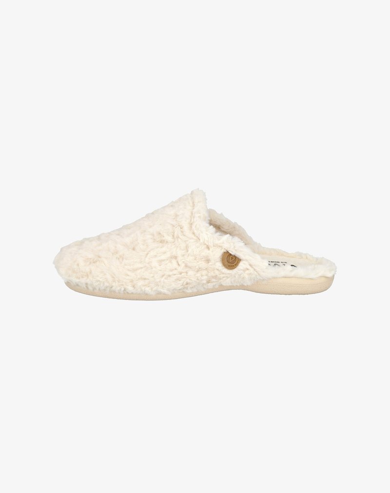 Zapatilla color crema con textura esponjosa, diseño tipo slip-on y punta redonda. Presenta un pequeño acento de logo circular en el lateral.