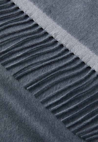 Textil gri cu franjuri, având o textură moale, asemănătoare cu bumbacul. Țesătura prezintă o suprafață netedă, cu franjuri tăiați uniform de-a lungul unei margini.