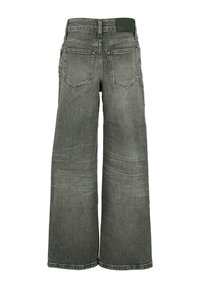 Jean large en denim gris foncé, présentant un design à cinq poches, une surface texturée avec un léger délavage et une étiquette logo sur la taille.