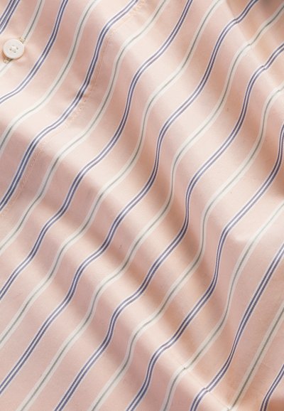 Tissu rose clair avec des rayures verticales bleues et blanches et un bouton blanc sur le côté gauche, montrant une texture lisse et des détails de couture.