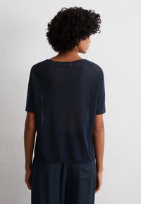 Donkerblauw T-shirt met korte mouwen, gemaakt van lichtgewicht, iets doorschijnend materiaal, met een ontspannen pasvorm en een ronde halslijn, gezien vanuit de rug.