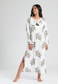 Lång vit klänning med mönster av gröna ormbunkar, lättviktig tyg, långa ärmar och en framknäppning med knytband och fransar samt sidoflikar.