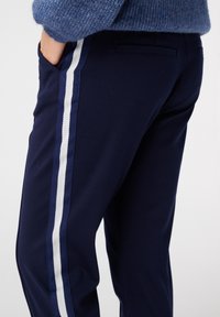 Navy broek met een slim fit, voorzien van twee verticale witte strepen aan de zijkanten, gemaakt van zachte katoen.