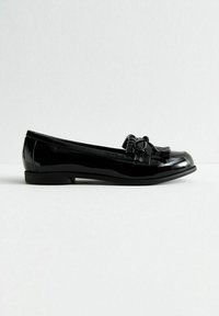 Ballerines en cuir verni noir avec un nez rond, un long pompon décoratif, et une finition lisse et brillante, dotées d'une semelle fine.