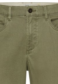 Groene katoenen broek in een blend met een sluiting met een knoop aan de voorkant, vijf zakken en een subtiele diagonale textuur. Voorzien van klassieke zilveren stiksels.