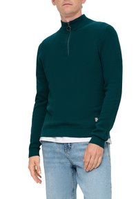 Türkisfarbener Pullover mit langen Ärmeln, hohem Kragen, halbem Reißverschluss auf der Vorderseite, strukturiertem Stoff und gerippten Bündchen, über einem weißen Hemd getragen.