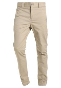 Béžové bavlněné kalhoty v rovné linii, se standardním pasem, zapínáním na přední knoflík a jemnou texturou. Žádné viditelné kapsy.