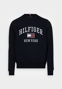Un sweat di cotone blu scuro con collo tondo, caratterizzato da un logo ricamato bianco "HILFIGER NEW YORK" e un accento di logo rosso e bianco sul collo.