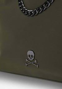 Oliivihreä laukku, jossa on teksturoitu pinta, musta ketjukahva ja metallinen pääkallon ja ristiluukku -embleemi edessä.