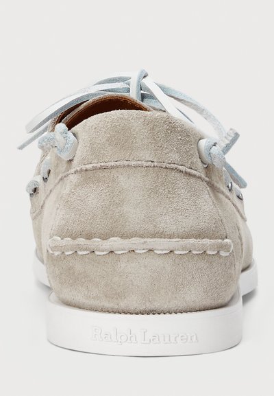 Suede gray boat shoe with a white rubber sole, featuring light blue laces and stitching details. Brand name is embossed on the heel.
