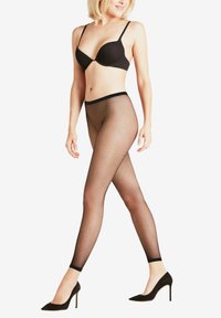 Zwarte visnetkousen met een hoge taille, met een stevige tailleband, gecombineerd met zwarte hoge hakken en een bijpassende zwarte bh.